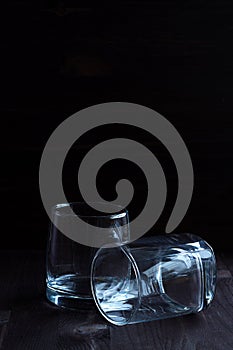 Glass of whiskey with ice on a wooden background.