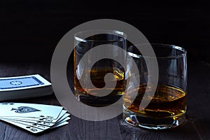 Glass of whiskey with ice on a wooden background.