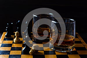 Glass of whiskey with ice on a wooden background.