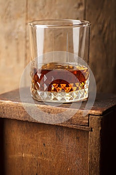 Glass of whiskey near a barrel