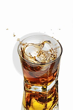 A glass of whiskey on a white background. Splash ice cube.