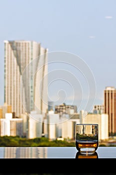 A glass of whisky with city view on background