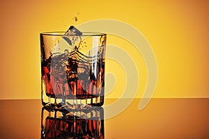 Glass of whisky with ice and splash photo