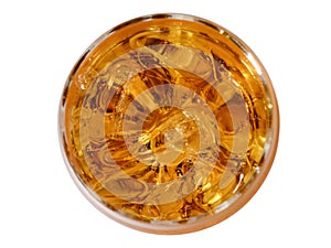Glass of whisky with ice pieces, the top view on a white background