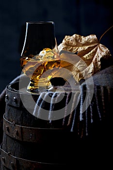 Glass with Whisky and a Leaf on Whisky Cask