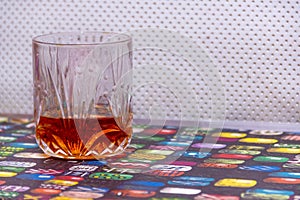 A GLASS OF WHISKY SITTING COLORFUL TABLE