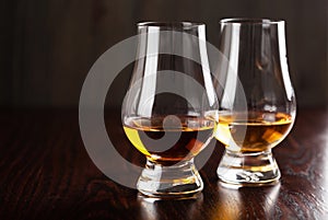 Glass of whisky spirit brandy on dark brown background