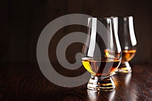 Glass of whisky spirit brandy on dark brown background