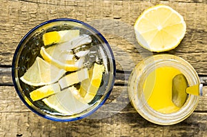 Glass of white sangria with lemon and honey jar