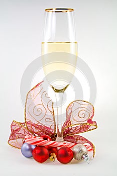 Glass of white wine with balls, candy cane and rib