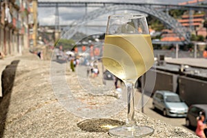 A glass of white wine with the bridge in the background