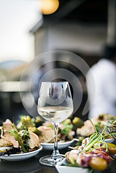 Glass of white wine with gourmet food tapa snacks outside