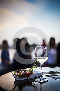 Glass of white wine with gourmet food tapa snacks outside photo