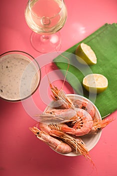 Glass with white wine, lime on a green napkin, shrimp in a bowl