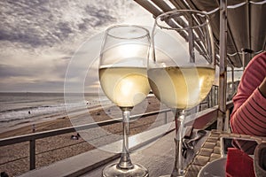 Glass of white wine overlooking the beach with sunset