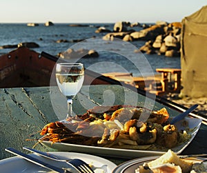 Glass of white wine and plate seafood, selective focus