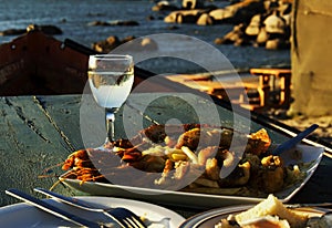 Glass of white wine and plate seafood, selective focus