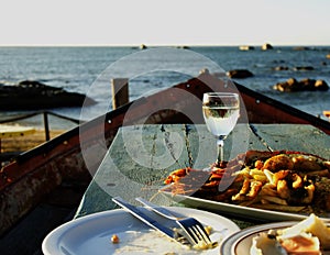 Glass of white wine and plate seafood, selective focus