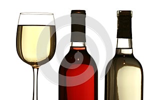 Glass of white wine, with red and white wine bottles