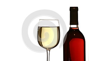 Glass of white wine, with red wine bottle