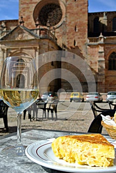 Glass of white wine and Spanish traditional potato omelet well known around the world as tortilla de patata
