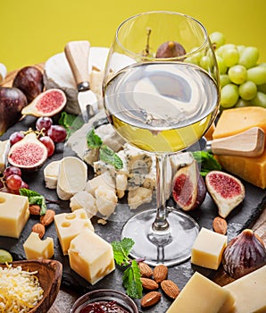 Glass of white wine with variety of sliced cheeses