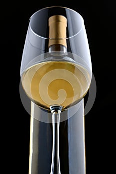 A glass of white wine and wine bottle