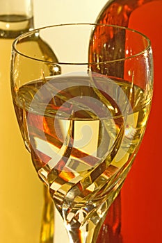 Glass of white wine with wine bottles