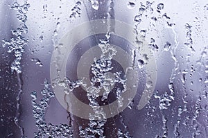 glass in the window covered with wet melting snow, close-up, macro photo