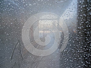 Glass window in frost in winter and with a heart pattern