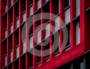 Glass window of skyscraper office building with red and white concrete wall. Exterior commercial building. Modern architecture