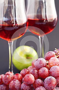 A glass of wine, apple and grape