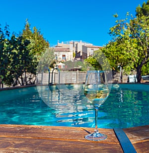 A glass of wine on the background of the pool in Siurana, Tarragona, Spain. With selective focus