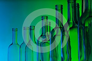 Glass wine bottle necks on green background