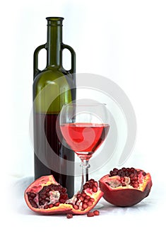 Glass of wine, bottle and a red pomegranate