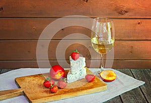 Glass of wine and cheese with blue mold with strawberries and nectarines