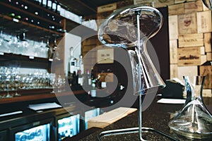 Glass wine decanter on a stand in a trendy wine bar
