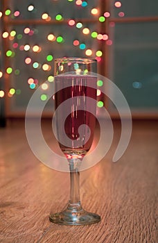 Glass of wine on garland christmas background