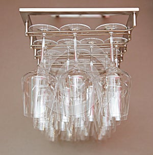 Glass wine glasses on bar suspension. Hanging Bar Glasses. Many empty clean glasses hanging in the bar, indoor. Wineglasses