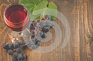 Glass of wine and grape/glass of red wine and grape on a wooden