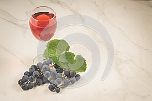 Glass of wine and grape/glass of wine and grape on a white marble, copy space