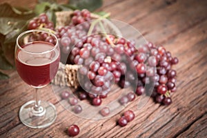 Glass of wine or grape juice and fruit on wooden table