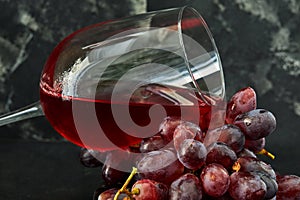 Glass of wine with grapes on a black wooden stand