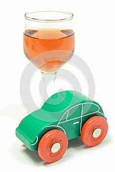 Glass of wine and green toy car. Don`t drink and drive concept. White background