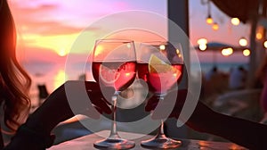 glass of wine in hand on evening pink sunset summer beach restaurant beach , romantic couple silhouette