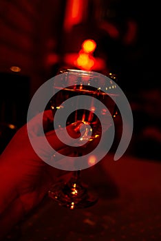 Glass of wine in red light, blurred. Party,joy