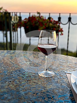 glass of wine in the landscape with dramatic sky during sunset