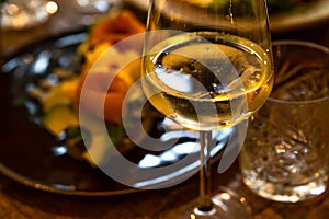 Glass of wine and plate with food on restaurant table