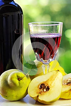 Glass of wine and quince fruits.