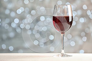 Glass of wine on table against blurred lights